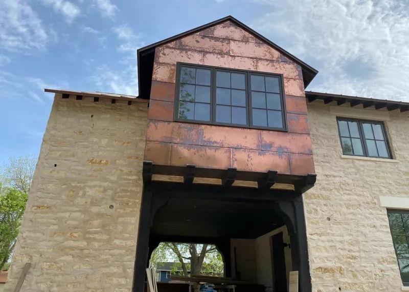 Copper metal panel facade on a stone building for Skylight Installation in Frankenmuth